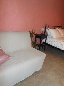 um quarto com uma cama branca e uma mesa lateral em Le Lasarde em Venasca
