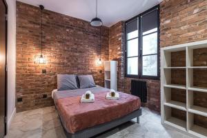 - une chambre avec un mur en briques et un lit dans une pièce dans l'établissement FEEL HOME - BUNICO, à Nice