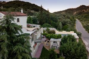 a house on the side of a hill with a road at Verekinthos Villas - Pool, Hot Tub, BBQ, Kids Playground, Stunning Mountain Views in Gerolakkos