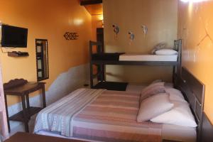 a bedroom with two bunk beds and a mirror at Pousada Mundial in Canoa Quebrada