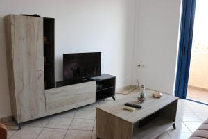 a living room with a large wooden entertainment center at Grammeno Seaside Studios in Palaiochora