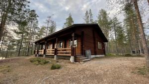 a small wooden cabin in the middle of a forest at Lapiosalmi Wilderness Center in Posio