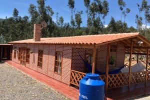 een klein rood bakstenen huis met een dak bij CABAÑA BUENAVISTA es un lugar para descansar. in Iza