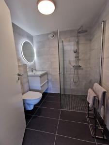 a bathroom with a shower and a toilet and a sink at Leilighet i Espeland in Bergen