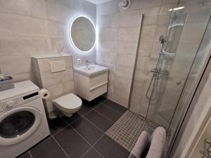 a bathroom with a shower and a toilet and a sink at Leilighet i Espeland in Bergen