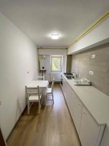 a kitchen with a table and a sink and a table at Mangalia Port in Mangalia