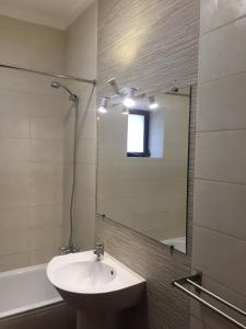 een badkamer met een wastafel, een spiegel en een bad bij CASA DA AVÓ in Vila Nova de Cacela