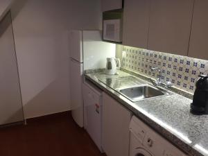 een kleine keuken met een spoelbak en een koelkast bij CASA DA AVÓ in Vila Nova de Cacela +14 foto's