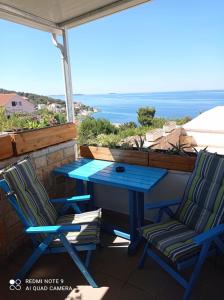 una mesa azul y sillas en un balcón con vistas al océano en Studio Apartman Lokvice, en Primošten