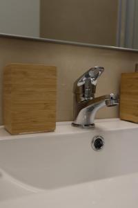 a bathroom sink with a faucet and a mirror at Breathe In in Zambujeira do Mar
