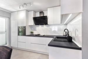 a kitchen with white cabinets and a black counter top at Silver Lux Suite - NEW in Zaboric