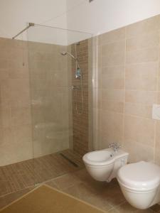 een badkamer met een toilet en een glazen douche bij Le Lasarde in Venasca