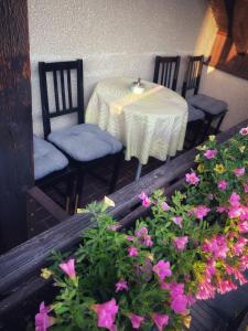 una mesa, sillas y flores en el balcón en R-Penzion, en Český Krumlov