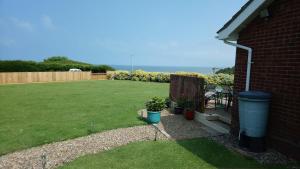 a backyard with a lawn with a fence and a table at The Room With The View in Overstrand