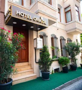 a hotel entrance with potted plants in front of it at Hotel Orkide in Istanbul