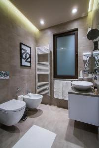 baño con 2 lavabos, aseo y ventana en Hotel Regal, en Korçë
