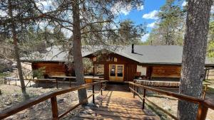a log cabin with a wooden walkway in the woods at Lapiosalmi Wilderness Center in Posio