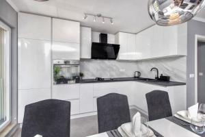 a kitchen with white cabinets and a table and chairs at Silver Lux Suite - NEW in Zaboric +22 photos