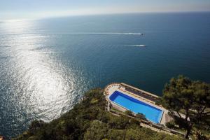 een zwembad op een heuvel naast het water bij Hotel Belvedere in Conca dei Marini