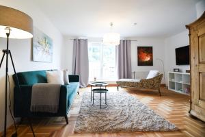 een woonkamer met een blauwe bank en een tafel bij Apartments Zum Ybbsturm in Waidhofen an der Ybbs