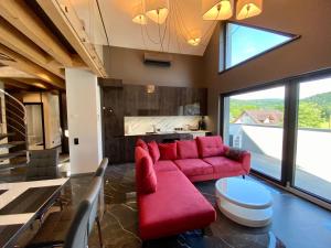Una sala de estar con un sofá rojo y una cocina. en Apartament LUX Ustroń, en Ustroń 36 fotos más