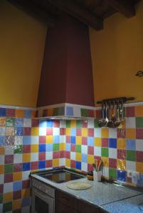 una cocina con azulejos coloridos en la pared en Casa Rural El Regajo, en Tenzuela