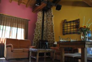 sala de estar con sofá y chimenea en Casa Rural El Regajo, en Tenzuela