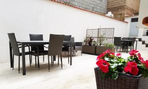 une table à manger noire, des chaises et des fleurs rouges dans l'établissement Appartamento tra mare e montagna, à Baunei 12 autres photos