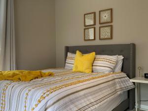 辛辛那提的住宿－Hyde Park Hideaway - Close to Square & Downtown!，一间卧室配有一张带黄色枕头的床