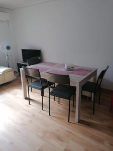 uma mesa de jantar com quatro cadeiras à volta em Malvarrosa apartamentos em Valência