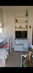 ein Wohnzimmer mit einem TV, einem Bett und einem Tisch in der Unterkunft Ático Roquetas in Roquetas de Mar