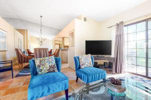 ein Wohnzimmer mit blauen Stühlen und einem Fernseher in der Unterkunft Mesquite Bungalow Permit# 1784 in Palm Springs