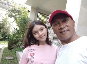 a man and a woman in front of a house at ThreeWin Homestay in Ubud