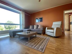 a living room with a couch and a table and a chair at Seaside Apartment in Haapsalu
