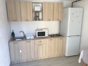 een keuken met een witte koelkast en een magnetron bij CasaRiana 5 in Eforie Sud