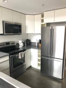 a kitchen with stainless steel appliances and white cabinets at Modern 2 Bdrm w/Parking in the Heart of Hillcrest in San Diego