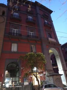 a tall red building with a tree in front of it at B&B Museum in Naples