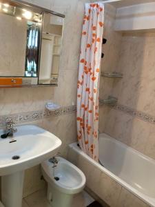 a bathroom with a sink and a toilet and a shower curtain at Casa Virginia in Sacedón
