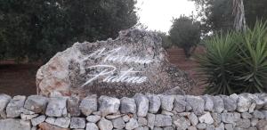 ein Stein mit Graffiti auf einer Steinwand in der Unterkunft Masseria Piatone in Ostuni