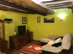 - un salon avec un canapé et une télévision dans l'établissement Casa Virginia, à Sacedón