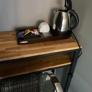 a tea kettle on top of a wooden table at HOTEL NATURE LE LOFT in Pierrelatte