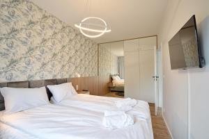 1 dormitorio con 1 cama blanca grande y pared en NORTH Apartments, PINE Mielno, en Mielno