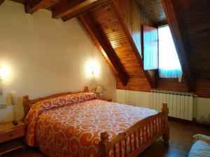 a bedroom with a bed in a room with wooden ceilings at Pension Casat in Salardú