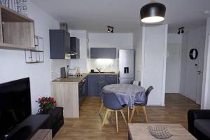 a kitchen with a table and a kitchen with a dining room at T2 moderne, lumineux, proche de la mer et des principaux accès routiers in Saint-Nazaire