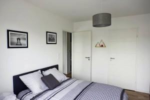 a bedroom with a bed with white walls at T2 moderne, lumineux, proche de la mer et des principaux accès routiers in Saint-Nazaire