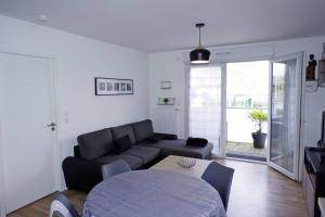 a living room with a couch and a table at T2 moderne, lumineux, proche de la mer et des principaux accès routiers in Saint-Nazaire