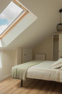 a bedroom with a large bed with a skylight at El Ático in Astorga