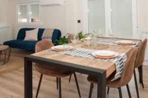 uma sala de jantar com uma mesa com pratos e copos de vinho em Apartamento El Ático em Astorga