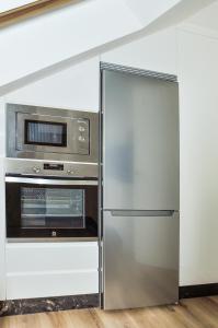a stainless steel refrigerator and microwave in a kitchen at El Ático in Astorga +13 photos