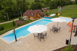 an overhead view of a swimming pool with tables and umbrellas at Penzion Malovaný in Osvětimany